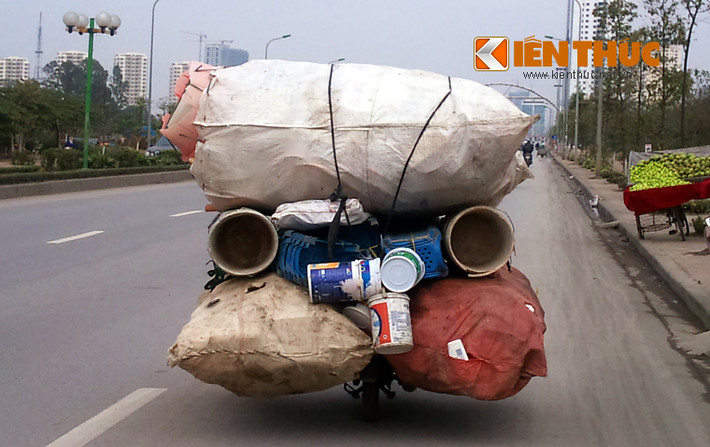 Xe máy "cà tàng" chở đủ loại đồng nát, phóng rất nhanh trên đường Lê Văn Lương kéo dài.