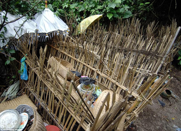 Trước khi đặt vào trong lồng tre, người chết được tắm rửa xác sạch sẽ bằng nước mưa và mặc trang phục để lộ phần đầu. Ảnh: AFP.