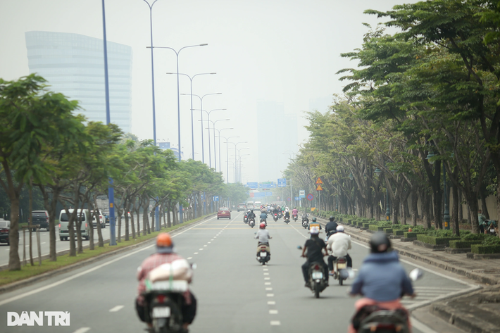 Vào lúc 11h, tuyến đường Mai Chí Thọ (TP Thủ Đức) hướng về hầm Thủ Thiêm (quận 1) vẫn mù mịt, những tòa nhà cao tầng phía trước mờ ảo trong lớp bụi mù (Ảnh: Hải Long).