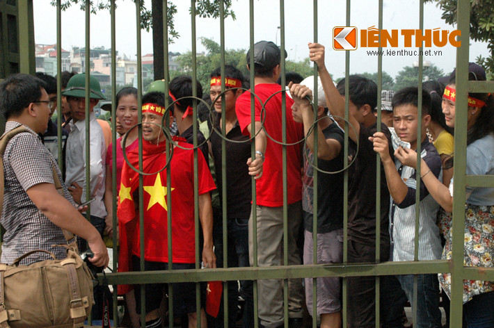 Gần đến giờ bán vé, nhiều người nóng ruột ngóng qua hàng rào.