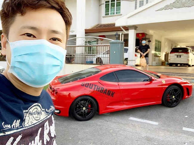 Nhân viên nhà hàng chụp ảnh selfie bên siêu xe màu đỏ khi có đơn hàng khách đặt đưa đến nhà.