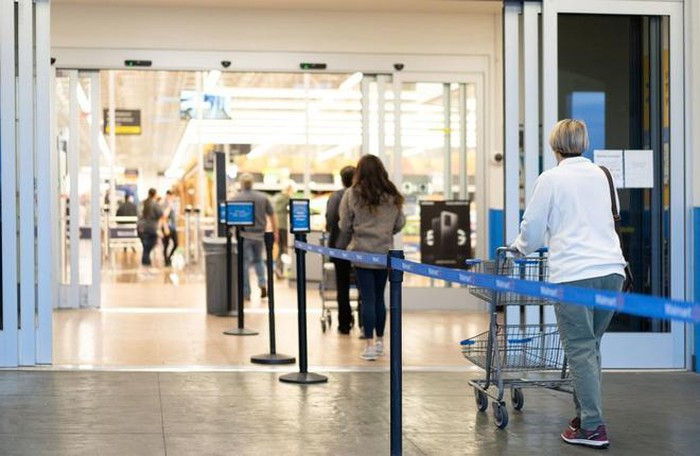 Khách hàng tuân thủ xếp hàng cách nhau ít nhất 2 m trước cửa hàng Walmart ở Los Angeles. Ảnh: LA Times.