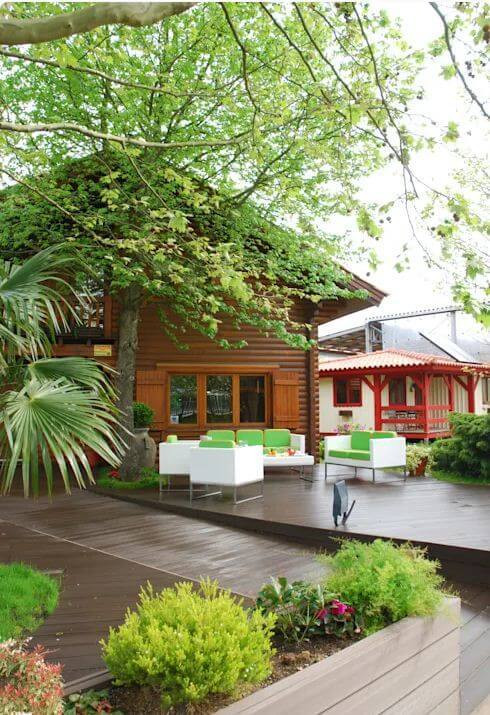 Điểm đặc biệt của biệt thự này chính là sân sau được lát gỗ, các món đồ nội thất có màu sắc nổi bật, tươi tắn tương phản thú vị với không gian xung quanh đem lại cảm giác vừa cổ điển vừa hiện đại