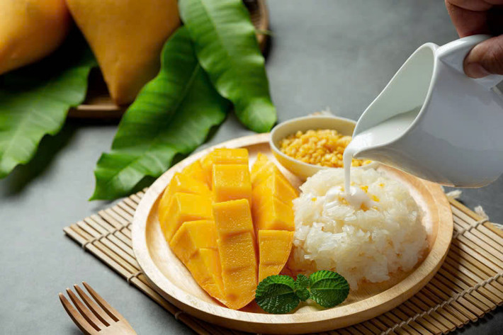 Xoài, quả nhiệt đới đặc trưng của Thái Lan, có hương vị ngọt ngào và vị chua nhẹ, mang đến cảm giác tươi mát trong những ngày hè oi bức. Khi kết hợp với xôi nếp – loại xôi được nấu từ gạo nếp, có độ dẻo và thơm ngậy, món ăn này mang lại một trải nghiệm hoàn hảo cho vị giác. Ảnh Chada Thai