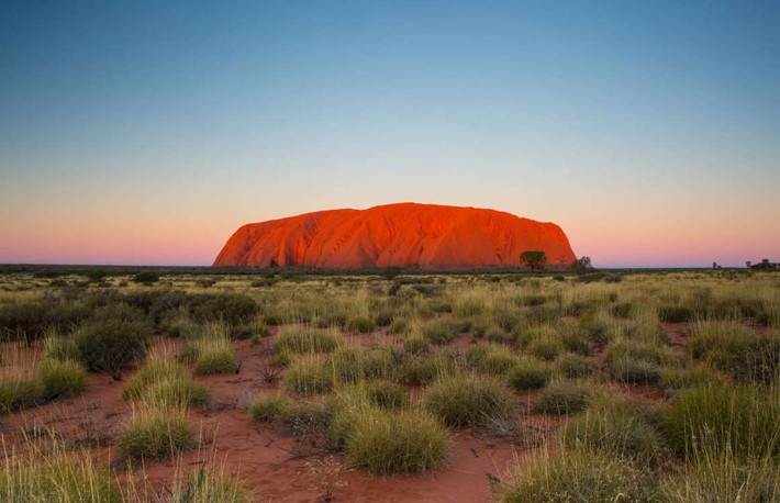 Uluru, Australia: Uluru hay Ayers Rock, nằm trong Vườn quốc gia Uluru-Kata Tjuta của Australia, nơi đã thu hút du khách từ nhiều thế kỷ. Các nhà khoa học cho rằng núi đá nguyên khối sa thạch này đã hình thành từ 550 triệu năm trước. Bề mặt màu đỏ của ngọn núi là do quá trình oxy hóa trong thời gian rất dài, trong khi phần đá phía dưới đáy có màu xám.
