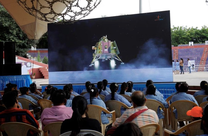 Người dân theo dõi chương trình truyền hình trực tiếp tàu vũ trụ Chandrayaan-3 hạ cánh trên Mặt Trăng, bên trong khán phòng ở Ahmedabad, Ấn Độ. Ảnh: Reuters.