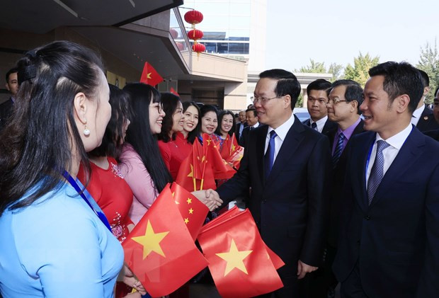 Cán bộ, nhân viên Đại sứ quán và cộng đồng người Việt Nam đón Chủ tịch nước Võ Văn Thưởng tại Sân bay Quốc tế Bắc Kinh. (Ảnh: Thống Nhất/TTXVN)