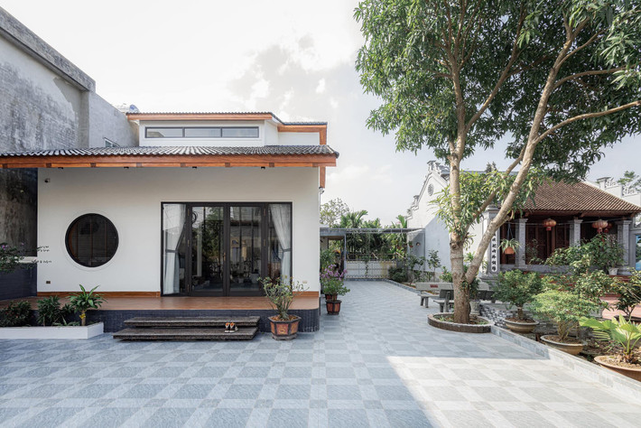 Diện tích xây dựng 90m2 nằm trong mảnh đất có khoảng sân rộng để trồng cây, đỗ xe, và chỗ vui chơi cho trẻ con. Đó cũng là không gian đệm trước nhà giúp hạn chế tiếng ồn, bụi vào nhà, mà vẫn giữ được nếp xưa "trước cau, sau chuối".
