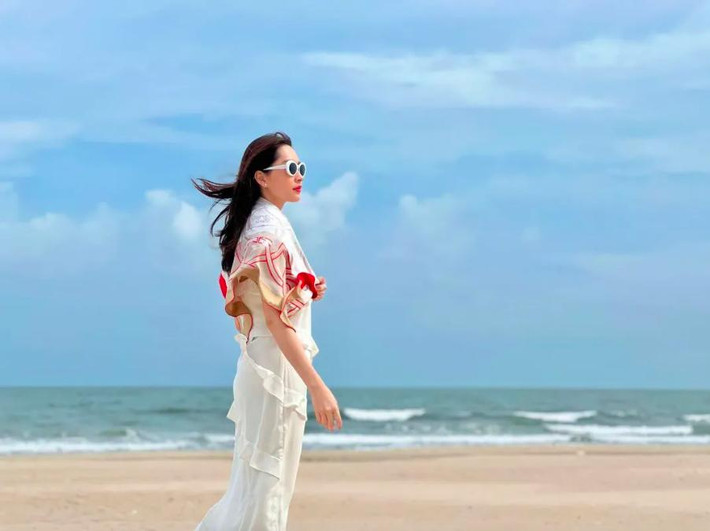 Diện đầm hai dây chất liệu mỏng manh, Đặng Thu Thảo hạn chế để lộ vóc dáng bằng cách choàng thêm khăn lụa.