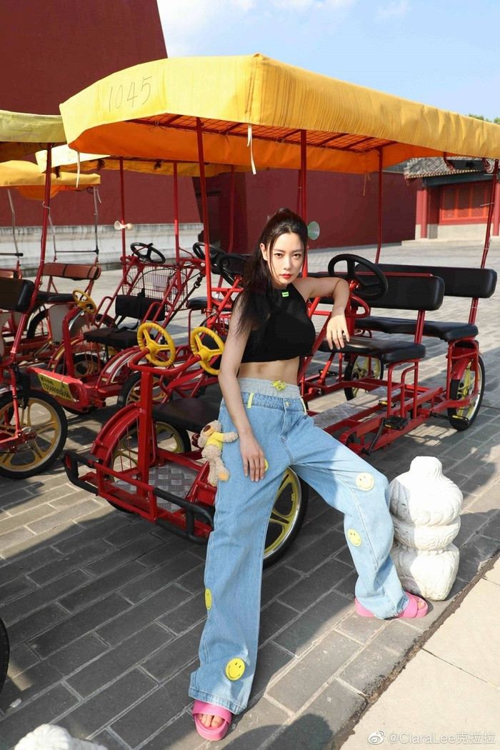 Trang phục dạo phố yêu thích của Clara chắc chắn là bra thể thao phối cùng quần dài. Trong bức ảnh này, cô diện quần tây cách điệu của hãng Ann Andelman. Cô còn tết tóc để làm tôn lên gương mặt nhỏ gọn của mình.