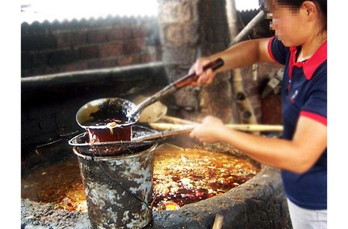 Người chế dầu bẩn dùng vợt để vớt lên những rác thải dạng rắn như xác động vật chết, xương, túi nylon…