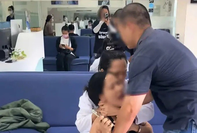 Bà Chinh dùng hai tay giữ chặt cổ khách hàng. (Ảnh cắt từ clip) 33.jpg