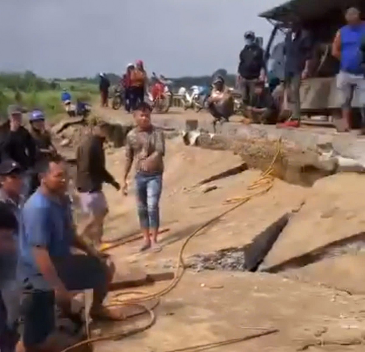 Đường bê tông đoạn bờ kè đã bị sạt lở do đợt mưa lũ tháng 11/2025 vừa qua bất ngờ đổ sập khi 4 người đang trú mưa phía dưới (Ảnh cắt từ Clip người dân cung cấp)