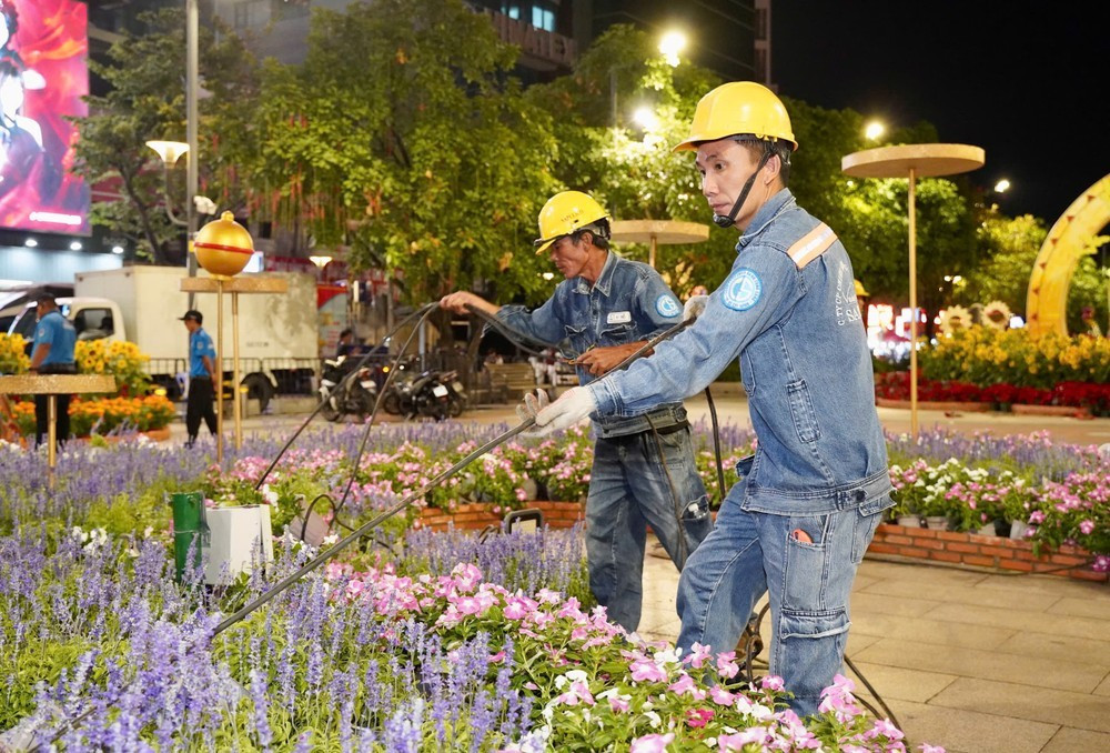 Phương tiện cơ giới và nhân viên điện lực của Công ty chiếu sáng TP.HCM tất bật tháo dỡ hệ thống điện chiếu sáng cho đường hoa, nhiều thiết bị điện chuyên dụng được vận chuyển ngay trong đêm.