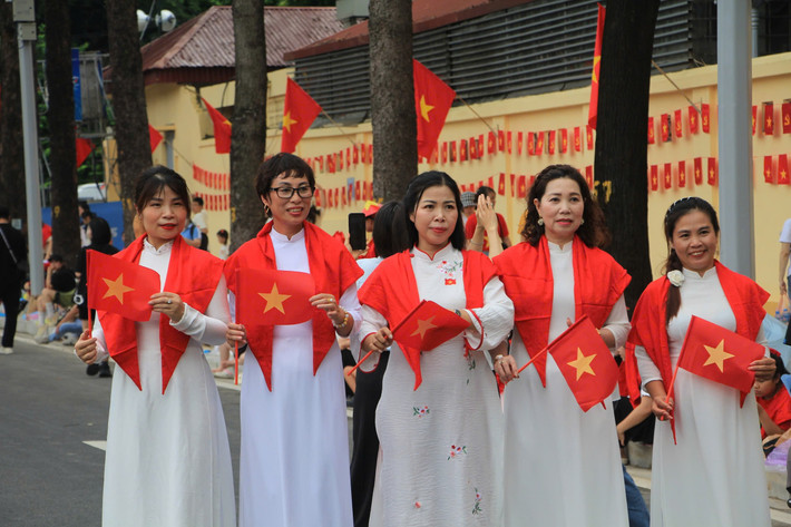 Tà áo dài trắng khiến màu quốc kỳ càng thêm nổi bật trong không khí rộn ràng chờ đón tổng hợp luyện A80.