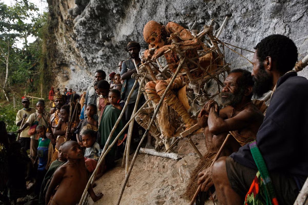 1. Tục hun khói xác chết: Bộ tộc Anga ở Papua New Guinea đặt thi thể người thân ngồi trên giàn gỗ và hun khói suốt 3 tháng để giữ nguyên hình hài và tránh linh hồn quấy nhiễu. Ảnh: NatGeo.