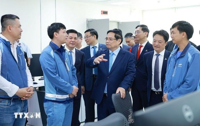 Thủ tướng Phạm Minh Chính với kỹ sư, chuyên gia điều hành Nhà máy điện LNG Nhơn Trạch 3 và 4. (Ảnh: Dương Giang/TTXVN)