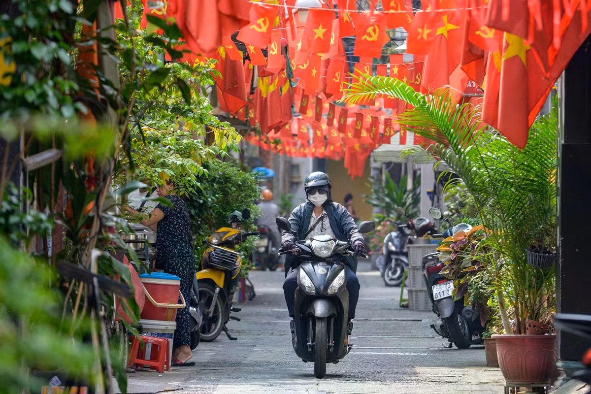 Không chỉ tại các trục đường lớn, nhiều con hẻm nhỏ cũng xuất hiện những dãy cờ Tổ quốc được treo trước nhà. Sắc đỏ của cờ và các băng rôn cổ động xuất hiện đồng bộ, tạo nên diện mạo đô thị trang trọng nhưng gần gũi với đời sống thường nhật của người dân.