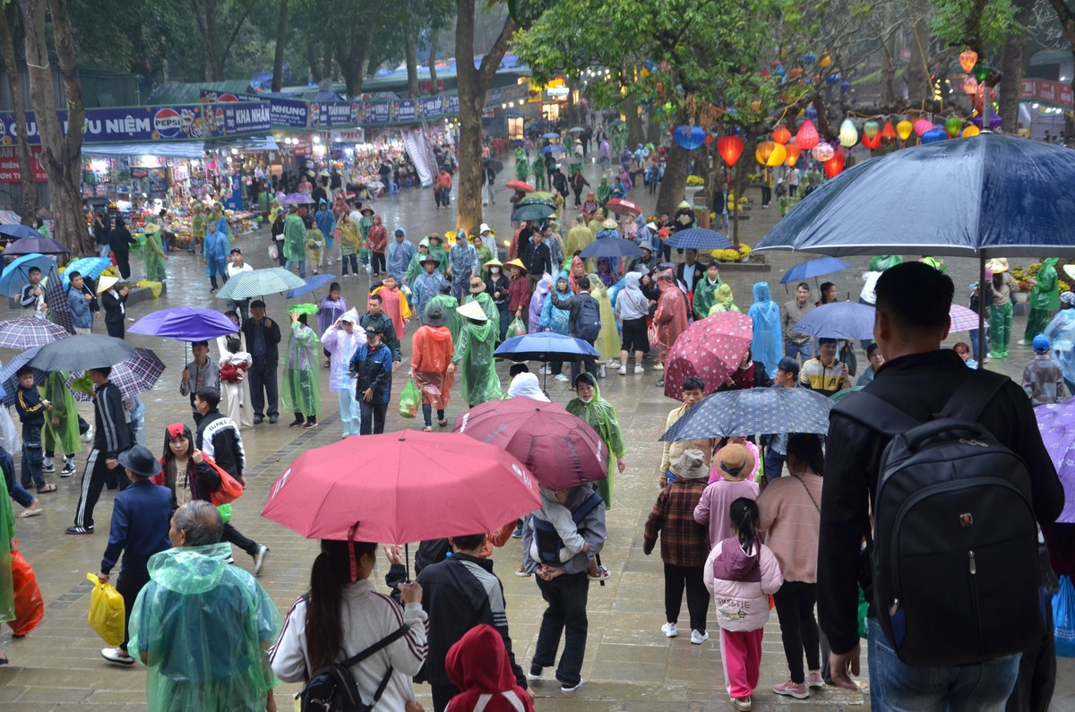 Du khách đội mưa đổ về khai hội chùa Hương sáng 22/2. Ảnh: BTC.