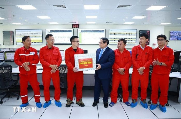 Thủ tướng Phạm Minh Chính tặng quà cho kỹ sư, chuyên gia điều hành Nhà máy điện LNG Nhơn Trạch 3 và 4. (Ảnh: Dương Giang/TTXVN)