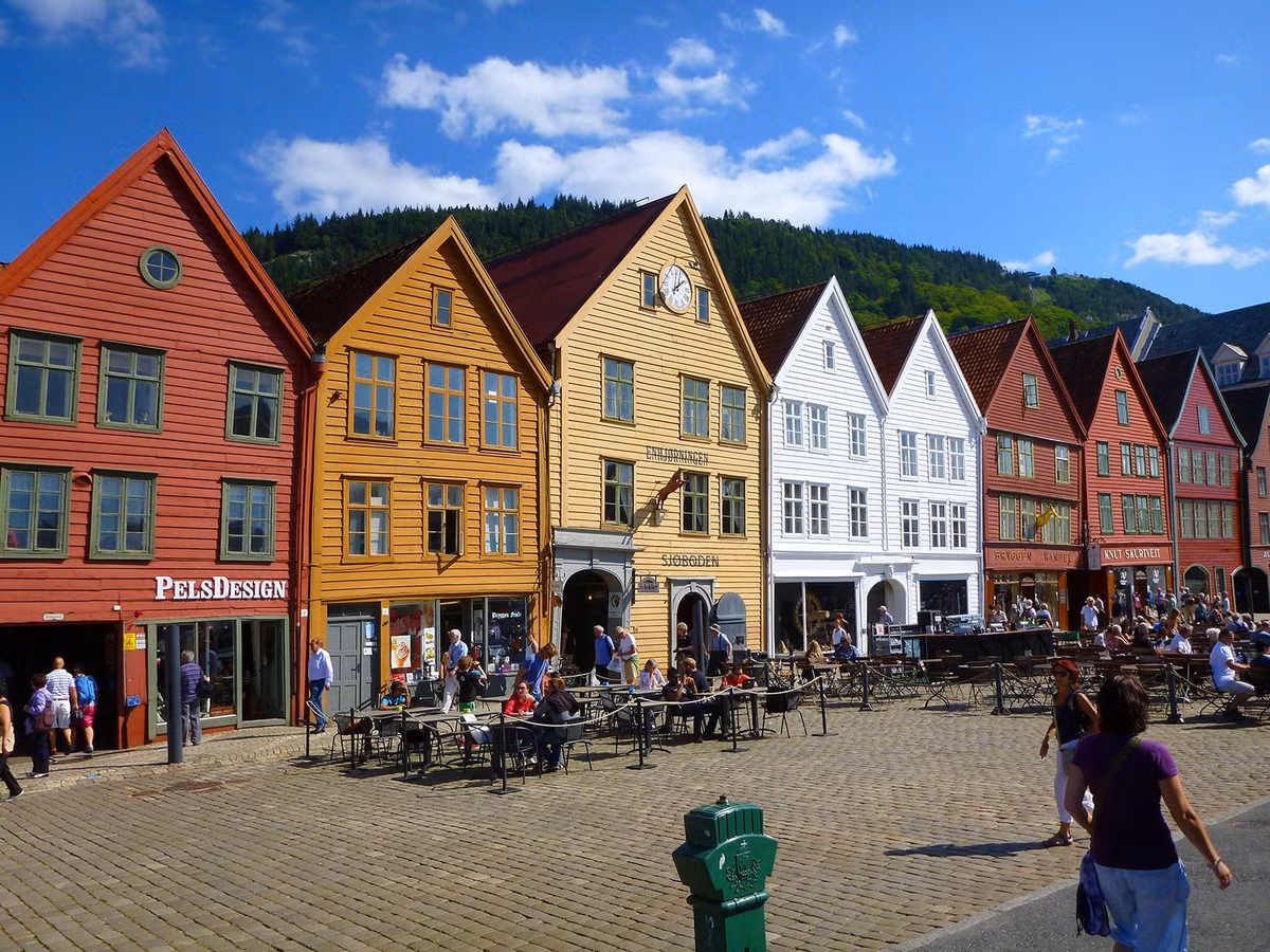  Những ngôi nhà gỗ nhiều màu sắc đặc trưng. Một trong những hình ảnh nổi bật nhất của Bryggen là dãy nhà gỗ cao và hẹp với nhiều màu sắc khác nhau như đỏ, vàng, trắng và nâu. Những tòa nhà này được xây dựng sát nhau dọc bến cảng, tạo nên khung cảnh cổ kính và trở thành biểu tượng du lịch nổi tiếng của thành phố Bergen. Ảnh: Pinterest.