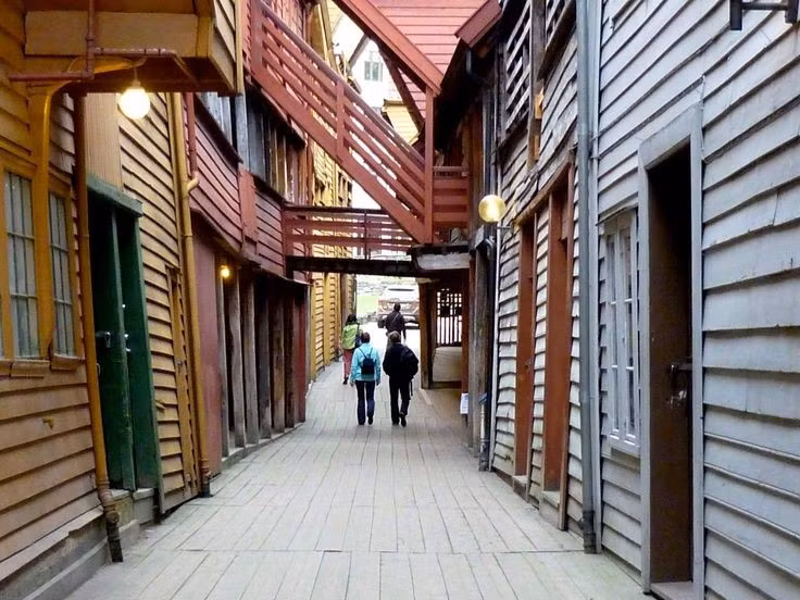  Bên trong là mạng lưới hẻm và sân gỗ độc đáo. Phía sau mặt tiền các tòa nhà là hệ thống lối đi hẹp, cầu thang gỗ và những khoảng sân nhỏ nối liền các công trình với nhau. Mạng lưới này từng là nơi lưu trữ hàng hóa, văn phòng và chỗ ở của các thương nhân Hanseatic trong thời kỳ hưng thịnh của Bryggen. Ảnh: Pinterest.