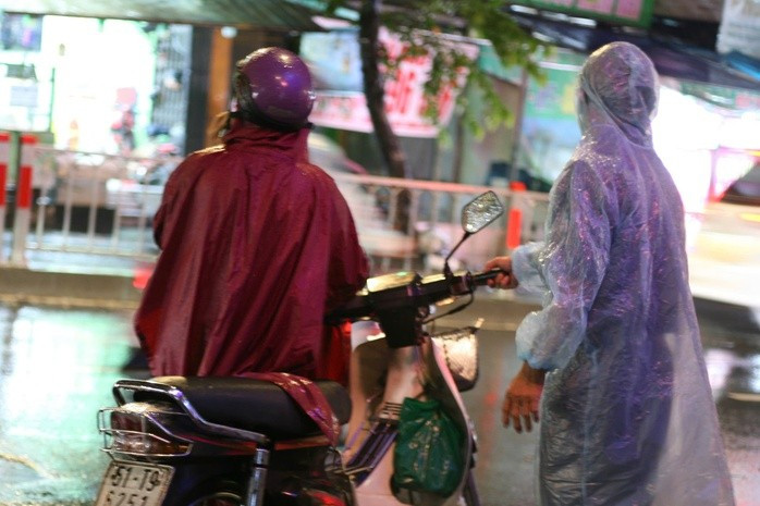 Nước mưa tràn vào ống pô, người dân phải tấp vội vào lề đường, liên tục đề máy trong cơn mưa đêm.