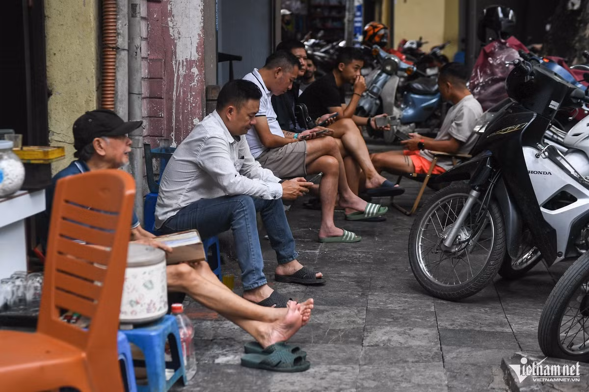 Nhiều khách hàng vẫn ngồi trên vỉa hè trước một quán cà phê. Khi có lực lượng chức năng đi qua nhắc nhở, những người này lập tức thu ghế đi vào nhà.