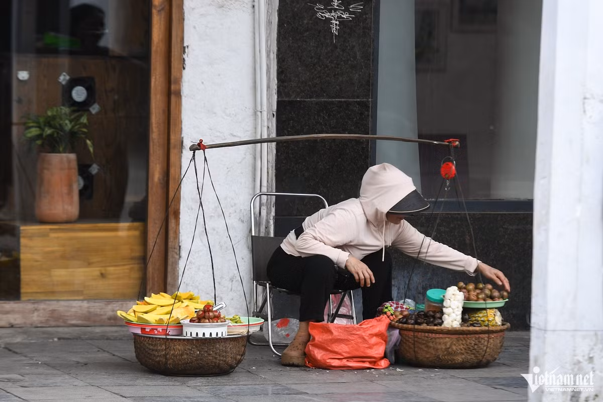 Tại một góc nhỏ trên phố Tràng Tiền, người phụ nữ bán hoa quả dạo vẫn kê ghế ngồi vẫy khách. Khi có lực lượng chức năng đi qua, chị nhanh chóng đứng dậy, gánh hàng lên vai như bình thường.