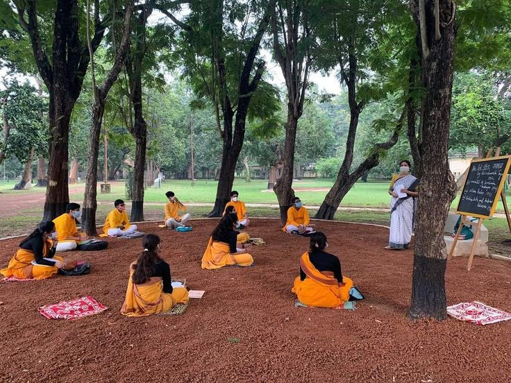  Lớp học diễn ra dưới bóng cây. Một trong những hình ảnh đặc trưng của Santiniketan là các lớp học ngoài trời. Sinh viên và giáo viên thường ngồi học dưới tán cây thay vì trong phòng kín, thể hiện triết lý giáo dục gần gũi với thiên nhiên và khuyến khích sự sáng tạo tự do. Ảnh: Pinterest.