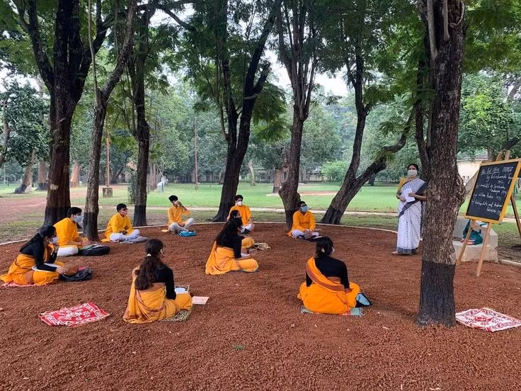  Lớp học diễn ra dưới bóng cây. Một trong những hình ảnh đặc trưng của Santiniketan là các lớp học ngoài trời. Sinh viên và giáo viên thường ngồi học dưới tán cây thay vì trong phòng kín, thể hiện triết lý giáo dục gần gũi với thiên nhiên và khuyến khích sự sáng tạo tự do. Ảnh: Pinterest.