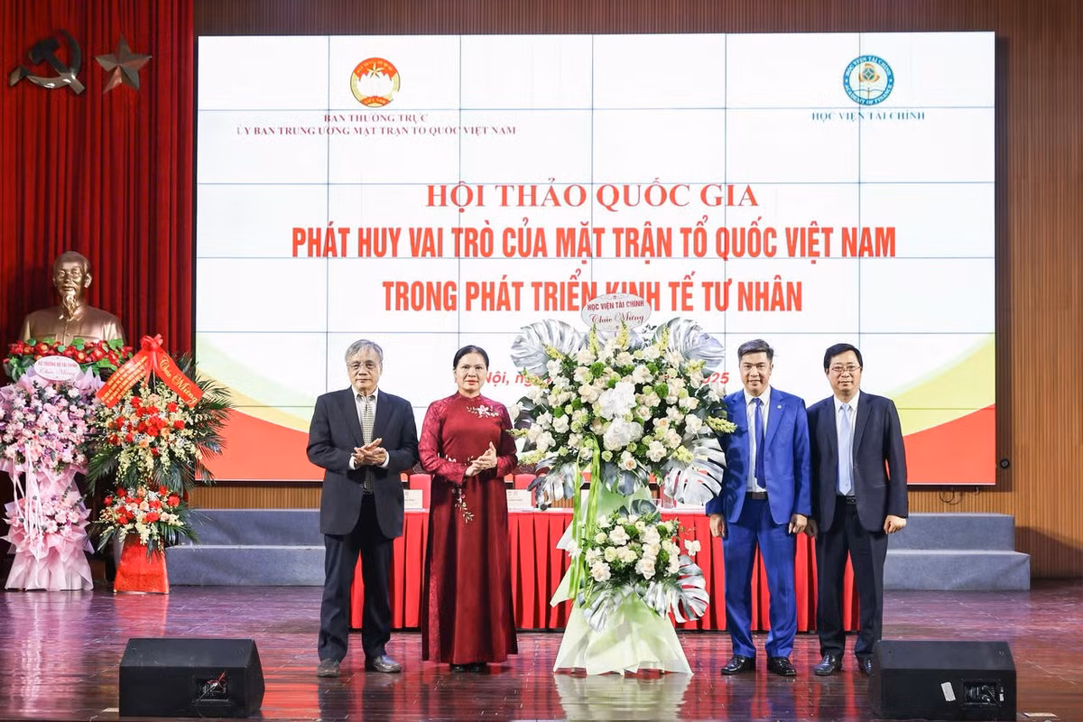 Phó Chủ tịch Hà Thị Nga và lãnh đạo Học viện Tài chính tặng hoa chúc mừng Hội thảo. Ảnh: Quang Vinh.