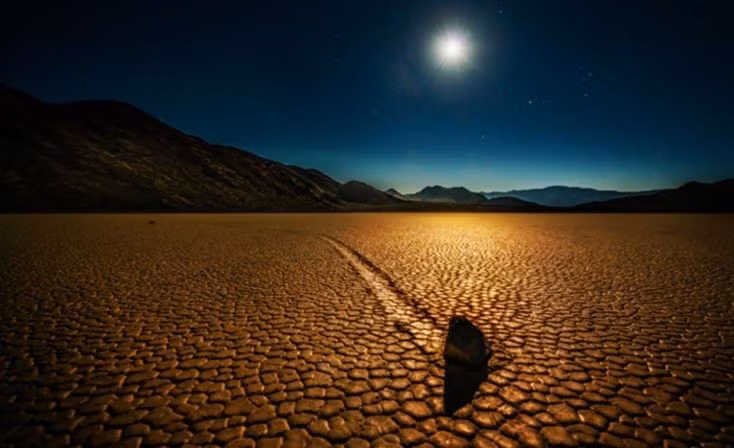  Thung lũng Chết và hiện tượng đá tự di chuyển. Tại Racetrack Playa thuộc Thung lũng Chết, nhiều tảng đá nặng hàng chục kilogram để lại những vệt dài trên mặt đất khô nứt, như thể chúng tự “đi bộ” mà không có tác động trực tiếp của con người hay động vật. Ảnh: Pinterest.