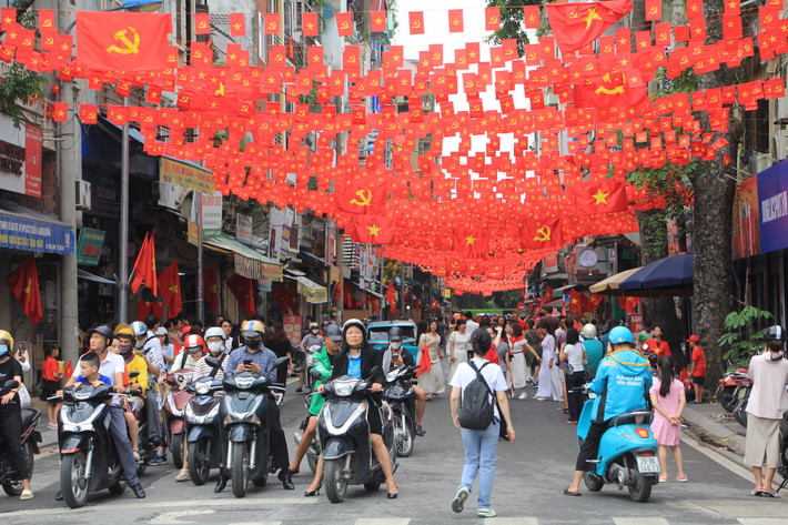 Khu vực xung quanh sân vận động Hàng Đẫy ngập cờ đỏ sao vàng. Các phương tiện giao thông cũng dẫn thưa thớt nhường lại cho người đi bộ.