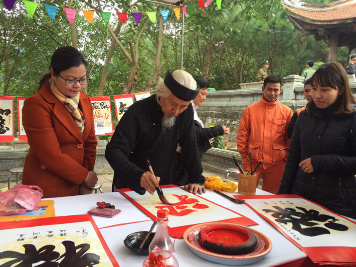 Nhà thư pháp Lê Thiên Lý cho chữ người dân.