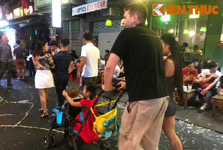 Từ tháng 8/2017, phố Bùi Viện chính thức khai trương "phố đi bộ", hoạt động từ 19h-2h sáng vào hai ngày cuối tuần thứ bảy và chủ nhật với hoạt động biểu diễn nghệ thuật. Đây là phố đi bộ thứ hai ở TP HCM sau phố đi bộ Nguyễn Huệ. Trong ảnh là một gia đình người nước ngoài cùng đưa con xuống phố đón giao thừa 2018.
