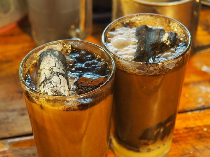 Cục than sẽ được thổi hết bụi tro, sau đó thả vào cốc cafe cho khách. (Ảnh Prawit Chankasem/Facebook)