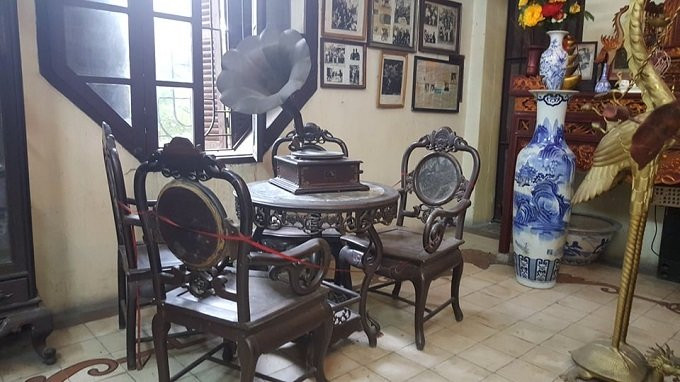 Một góc căn phòng vẫn còn lưu giữ bộ bàn ghế gỗ và chiếc máy hát cổ.