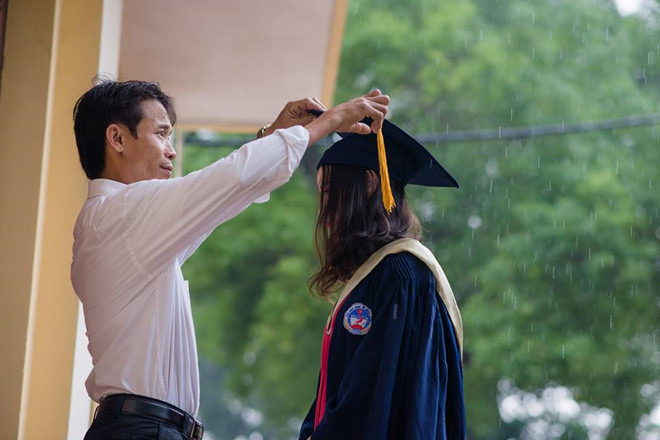 Ngày 15/11, bức ảnh kỷ yếu "Cha và con gái" khi trời mưa nặng hạt trở thành tâm điểm chú ý trên mạng. Khoảnh khắc này không quá đặc biệt, song câu chuyện về người cha nghèo bắt xe từ 4h sáng lên thành phố để chụp hình cùng con khiến mọi người cảm thấy ấm lòng. Ảnh: Nguyễn Thái Sơn.