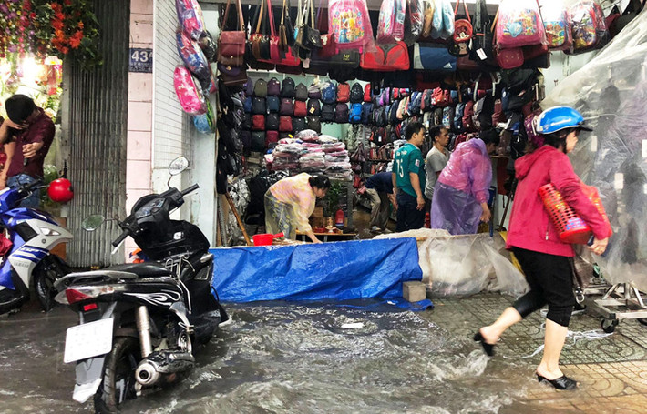 Mưa lớn khiến nước tràn cả vào nhà dân gây hư hỏng đồ đạc, một số người phải hì hục tát nước ra ngoài.