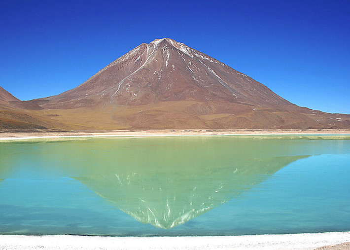 10. Laguna Verde Laguna Verde, một hồ nước mặn, nằm ở phía tây nam của đồng bằng cao của Bolivia. Đối với những người nói tiếng Tây Ban Nha, sẽ không có gì ngạc nhiên trước vẻ đẹp của hồ nước với tên gọi Laguna Verde (Đầm xanh) này. Hồ có một màu xanh tuyệt vời. Nằm dưới chân núi lửa Licancabur, màu xanh lá cây tươi đẹp của nước hồ cộng hưởng với màu vàng đồng của ngọn núi tạo thành một khung cảnh nên thơ.