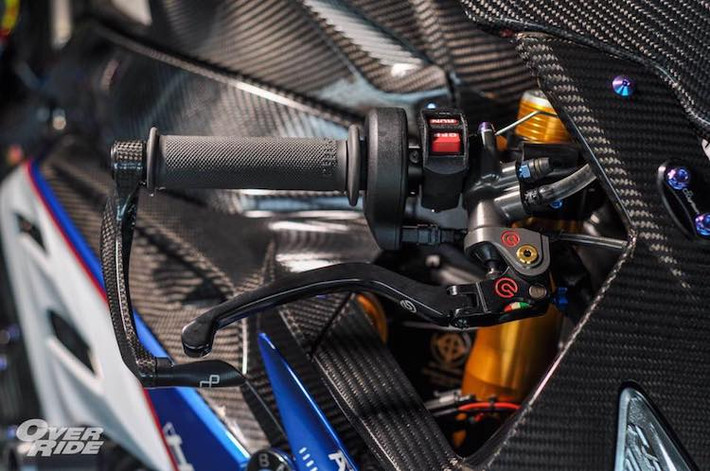 Trong khi đó, ở bên phải là sự xuất hiện của cùm phanh Brembo Rossi đẳng cấp, được bảo vệ bởi càng Lightech bằng sợi carbon nhẹ nhưng cứng cáp. Hai bên thân của chiếc xe cũng được bảo vệ trong trường hợp tai nạn nhờ cặp chống đổ Motovation, trong khi dàn quây gió được trang trí theo phong cách phiên bản HP4.