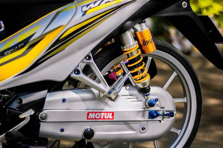 Trong khi đó, cặp lốp mỏng Dunlop và hệ thống phuộc sau Ohlins khiến cho chiếc xe có cảm giác lái ổn định hơn khi đi trên đường. Cuối cùng, những con ốc titan màu xanh tạo thêm điểm nhấn ở khắp nơi trên chiếc Wave S này.