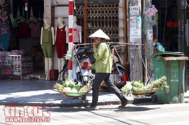 Cô bán hàng rong đi như chạy để tránh nắng gay gắt.