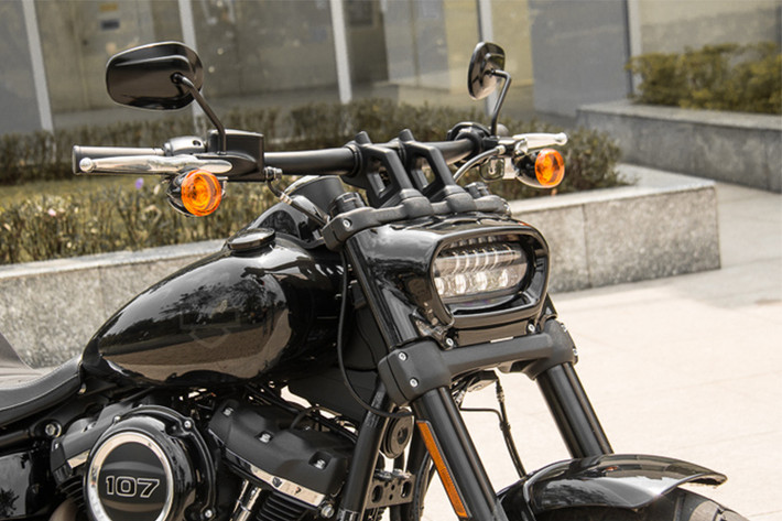 Điểm ấn tượng đầu tiên của Fat Bob 2018 là thiết kế đèn pha trước - nó là mẫu xe hiếm hoi mà Harley-Davidson xuất xưởng với cụm đèn pha đặt ngang. Cụm đèn trước được tích hợp hệ thống chiếu sáng Projector với các dãy LED định vị siêu sáng. Phía dưới ghi đông là hai đèn xi-nhan rời, giúp phần đầu hung hãn khi nhìn trực diện.