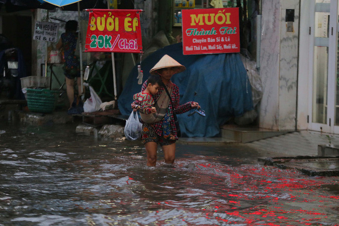 Nhiều người dân tỏ ra mệt mỏi khi đi qua khu vực ngập này.