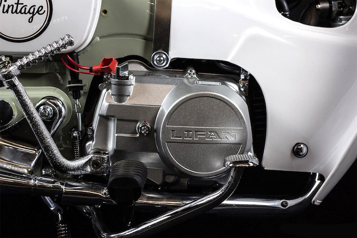 Trong khi đó, bưởng côn của chiếc xe lại có thiết kế giống Honda Dream. Vẫn sử dụng chế hòa khí và có 1 xi-lanh nằm ngang SOHC, động cơ này tạo ra công suất tối đa 8 mã lực. Lifan cũng tích hợp cho Vintage bộ đề để khách hàng không phải đạp nổ như những chiếc Cub đời cũ.