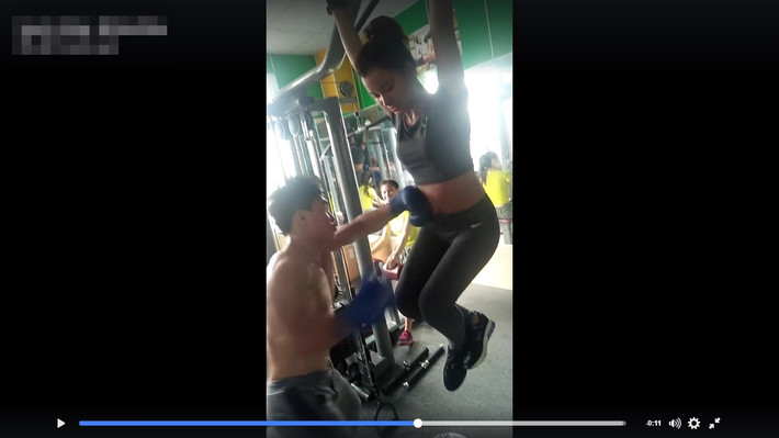 Hình ảnh từ clip quay tại một phòng tập gym cho thấy, cô gái xinh đẹp này vừa đu xà vừa để cho một chàng trai cơ bắp mang găng tay đấm túi bụi vào bụng mình trong suốt 30 giây.
