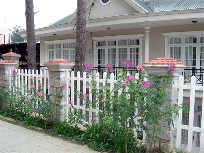 Căn nhà nhỏ xinh, bao quanh là hàng rào trắng cùng những đóa hoa leo trên tường rào điểm xuyết màu xanh, đỏ, cam, vàng … tạo nên nét đẹp nên thơ không thể rời mắt. Ảnh: Hangraodep.