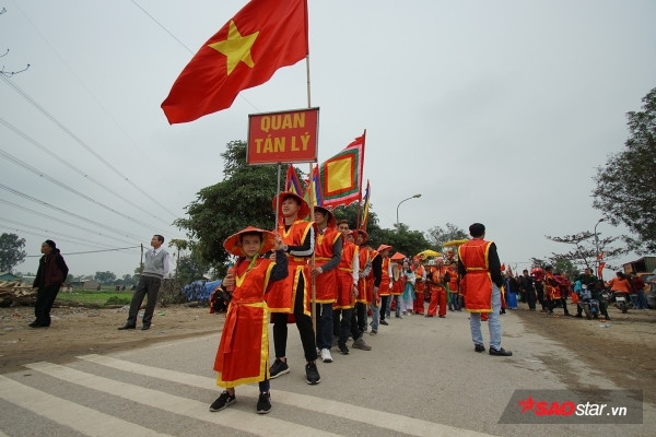 Được biết, mỗi năm người dân trong làng lại chọn ra những người cao tuổi xứng đáng để vào vai “vua, chúa” và 4 vị quan tứ trụ triều đình. Tất cả phải khỏe mạnh; còn đủ song toàn cụ ông, cụ bà; có đức độ và có uy tín trong dân chúng. Trong ảnh, trước khi màn rước “Vua, chúa sống” là lễ khênh kiệu từ đình làng về đền Sái với màn quay kiệu hừng hực khí thế và vui nhộn. Ảnh: Tường Bách.